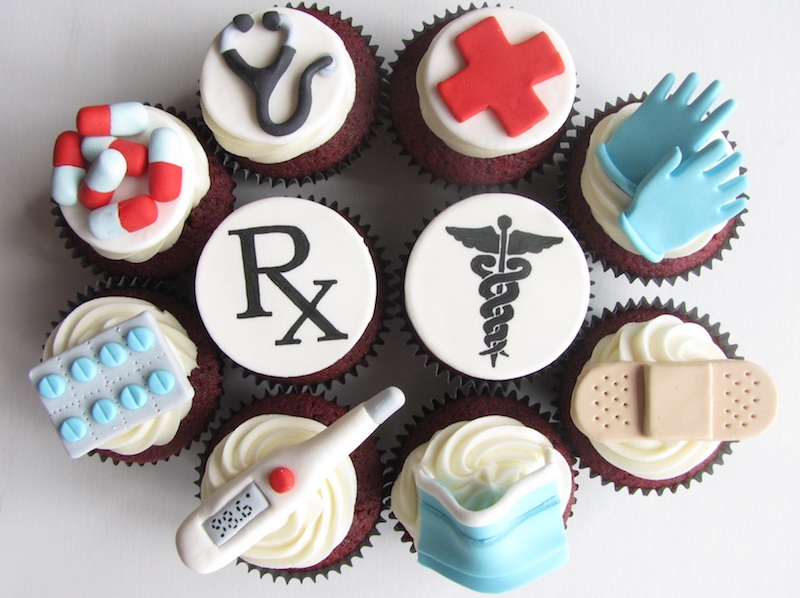 Various cupcakes with medical icons on top of frostings