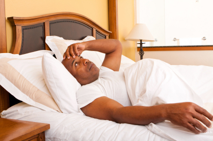 Older Man Lying in Bed Exasperated and Staring at Ceiling