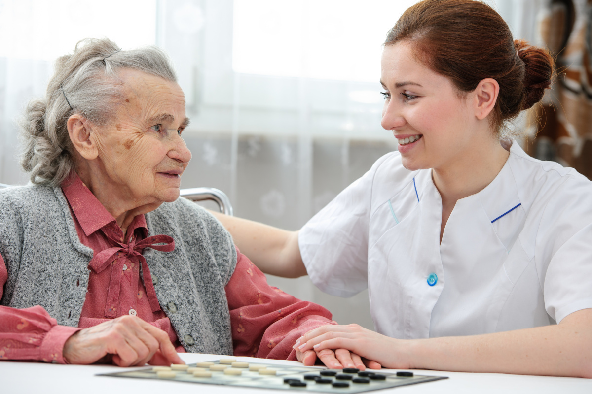 Young Nurse with Elderly Patient in Care Facility