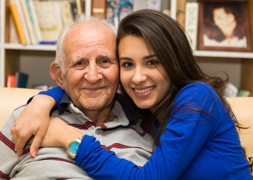 Elderly man with granddaughter in a home setting.