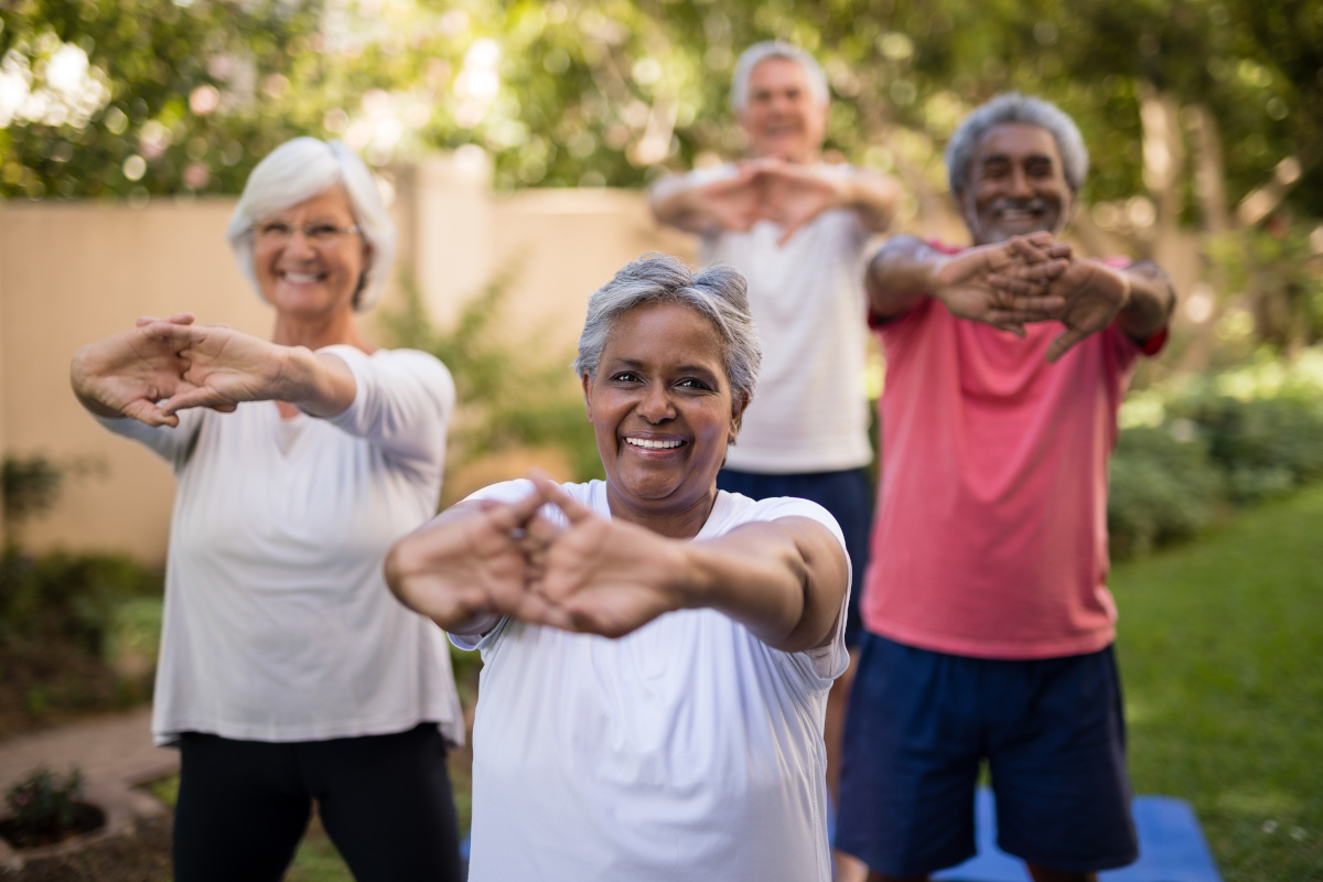 Four Senior Women and Men Smiling and Stretching Outdoors
